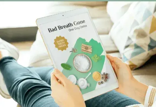 Reading the one-day oral detox and teeth hacks guide on a digital tablet.